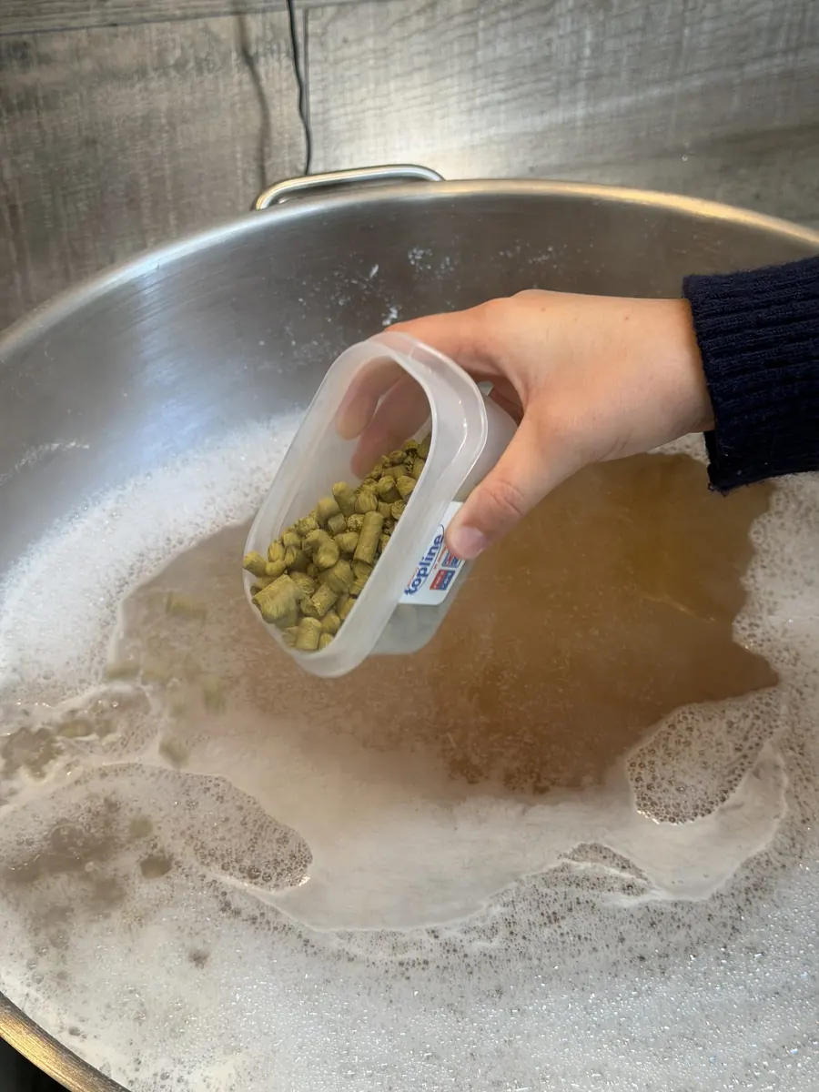 Hopfen wird von Hand in die Maische gegeben